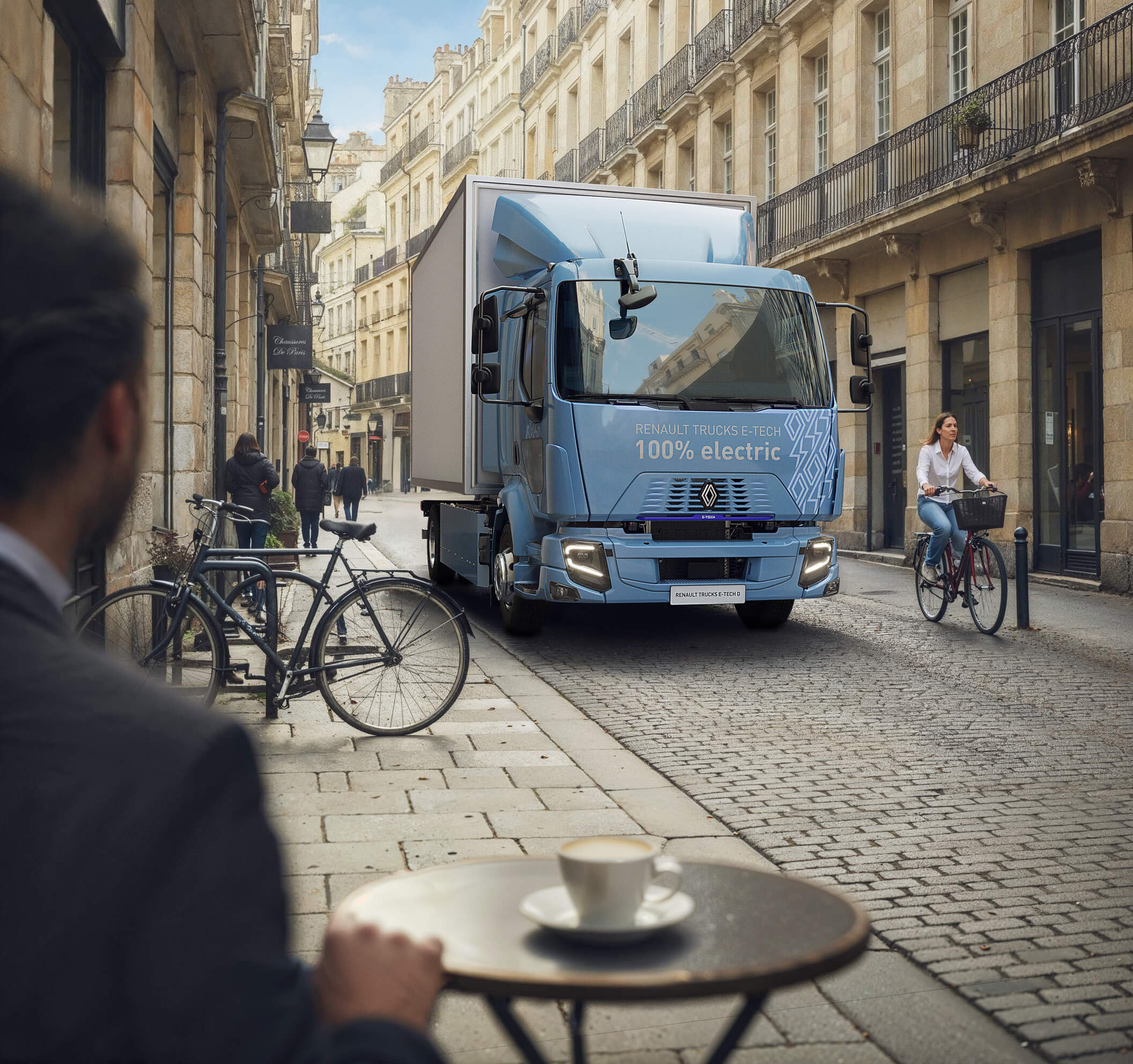 Renault Trucks E-Tech D 14t in a city center passing by a french bistrot