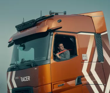 Modelljahr 2025: Renault Trucks T High Smart Racer: Lifestyle; Fahrer am Steuer beim Anlegen seines Sicherheitsgurts (Renault Trucks Hero Zip Hoodie)